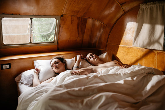 Young cute couple sleeping together at bed