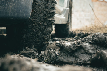 Car mud terrain wheel on dirt road background.