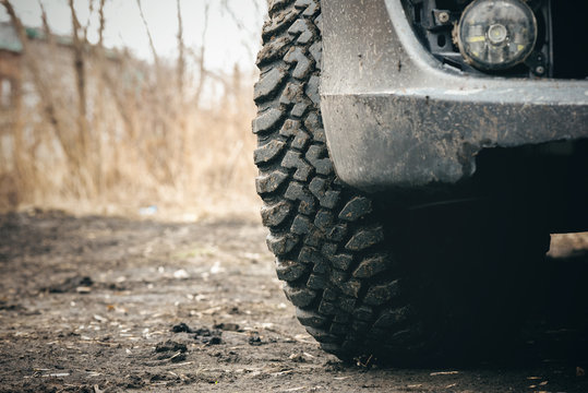 Car Mud Terrain Wheel On Dirt Road Background.