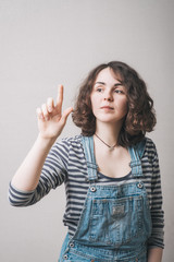A beautiful young adult woman touching in the air with one finger