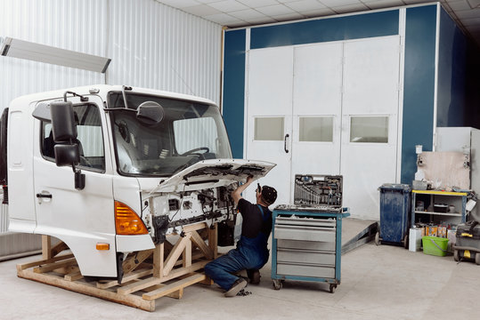 Auto Service Worker Repairing Truck Front End