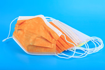 Colorful medical masks isolated on blue background. Surgical mask with rubber ear straps. Protection concept.