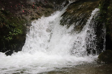 Beautiful landscape of cascade falls over mossy rocks, stones cover with moss, in a Mountain in Sichuan, China