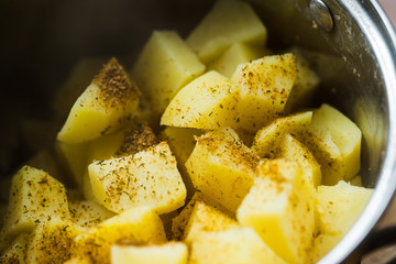 Photo of boiled potatoes with seasoning in a pot