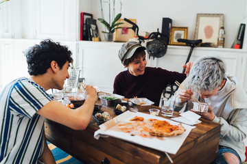 Happy Friends Enjoying Food Party At Home
