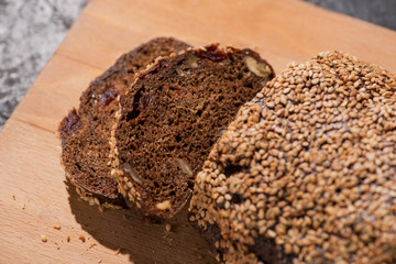 fresh baked black bread with sesame on cutting board