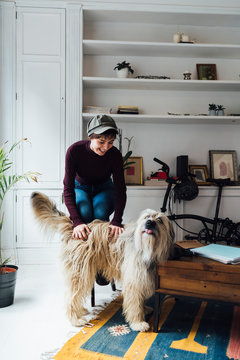 Student Playing With Hairy Dog At Home