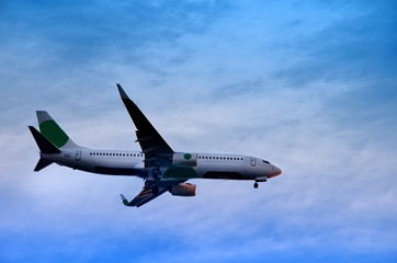 A large plane flies in the evening blue sky, a dramatic sky with clouds over Porto in Portugal..