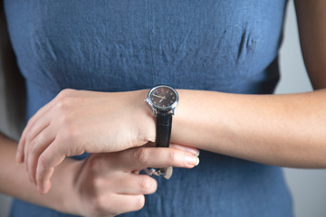 woman hand holding black watch