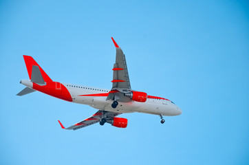 A beautiful corporate plane flies in the sky, a clear day in Portugal, tourist transport and mail delivery. bottom view.