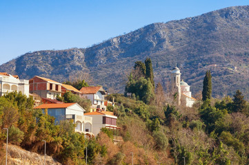 Fototapeta na wymiar Picturesque Mediterranean village on side of mountain. Montenegro, Kamenari village, Church of Sveta Nedjelja