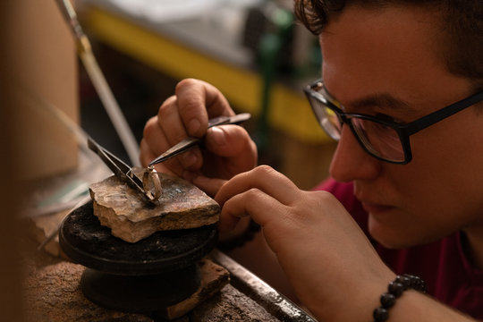 Jeweler putting gem on ring