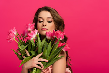 beautiful girl holding bouquet of tulip flowers isolated on pink