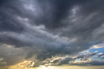 Sunset sky covered with dramatic storm puffy clouds before rain.