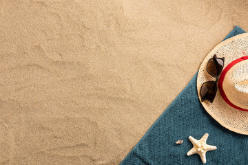 Beautiful summer holiday beach background with straw hat and seashels on sand background, border design, top view with copy space