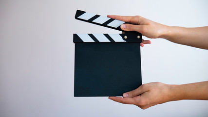 Empty wooden clapperboard in women's hands. Negative space. 