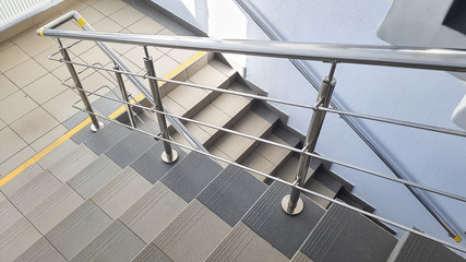Staircase at the entrance of a multi-storey building. Steps of stairs in the staircase. View from the landing down.Stairs inside the building.Stairwell in a modern building. Empty stairwell