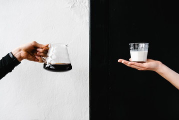 Hands holding coffee and milk
