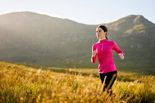 Fit attractive woman running in nature