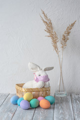 Easter in punishment. Easter bunny in a medical mask and colored Easter eggs. Vertical