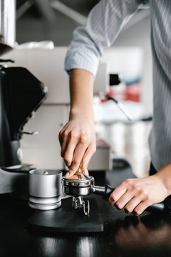 Female using professional machine tampers for making coffee.