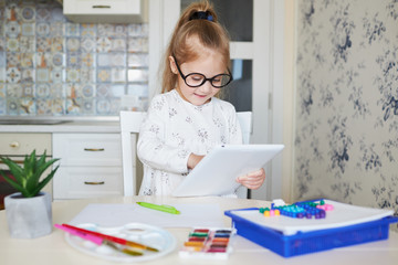 Online Education concept. Little child girl using laptop for distance learning at home