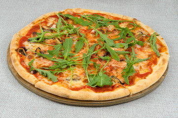 Mushroom pizza with a lot of cheese and arugula on a gray background