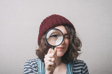 Young beautiful woman with magnifying glass.