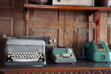 Gray vintage typewriter and placed antique green telephone for room decoration