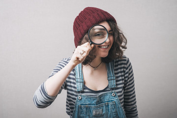Young beautiful woman with magnifying glass.