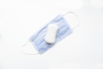 A piece of white soap on a medical mask, top view.
