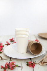  disposable eco tableware from paper cardboard spoon fork knife on a white wooden table, top view.