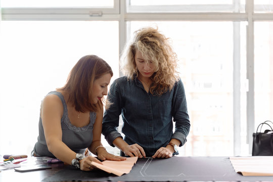 Women creating dress pattern together