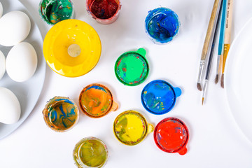 Children are preparing for Easter. Coloring eggs with brushes and multi-colored paints