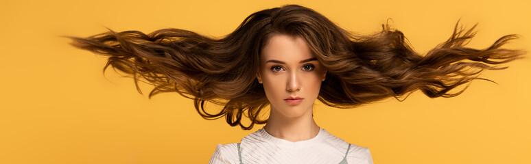 Naklejka premium panoramic shot of beautiful confident spring woman with long hair isolated on yellow