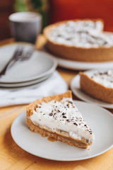 appetizing slice of sand-based dessert with white cream cheese and banana stuffing sprinkled with grated chocolate