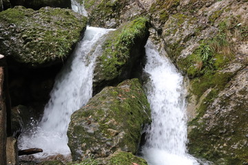 Beautiful landscape of cascade falls over mossy rocks, stones cover with moss, in a Mountain in Sichuan, China