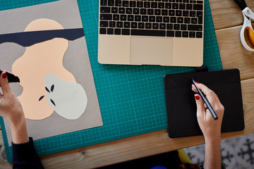 Creative woman using graphic tablet to make a collage