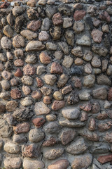 Masonry of multi colored small stones with a vertical crack