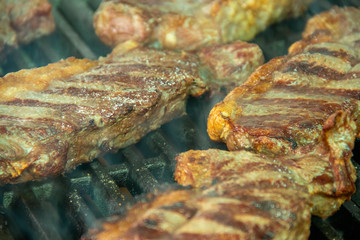 Steaks grilling on smoking hot char broiler grill