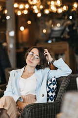 Portrait of a pretty girl of European race. She's wearing a light gray jacket. A photo with a blurred background.