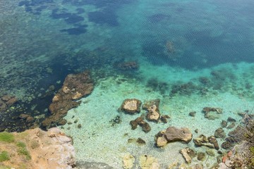 Beautiful view of the sea with differente blue graduation of color - turquoise water and rocky seabed in Sicily