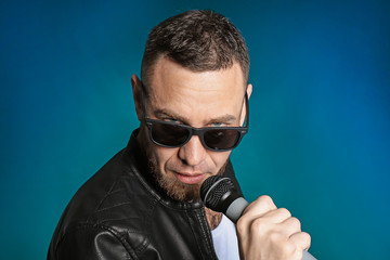 Male singer with microphone on dark background