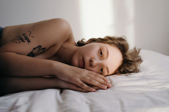 Topless chubby woman lying on bed