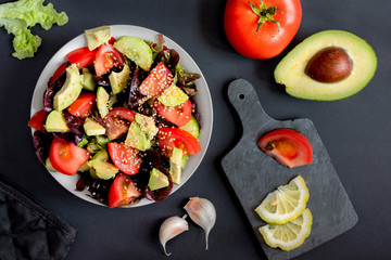 salad of greens, avacado, cucumbers and tomatoes with sesame