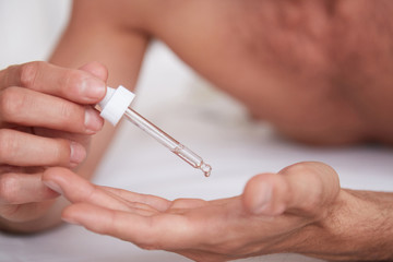 Man using oil serum skin