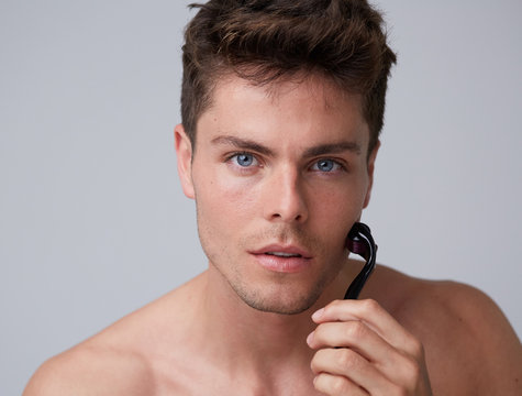 Man using needle derma roller
