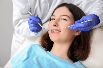 Teenage girl with dental braces visiting orthodontist in clinic