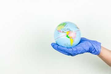 globe in the hands with rubber gloves, the concept of disinfection in the world