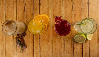Fruit flavored waters, very typical of Mexico, among the flavors in the photo; Cevada with cinnamon, Orange, Jamaica, Lemon. On a wooden table. 2